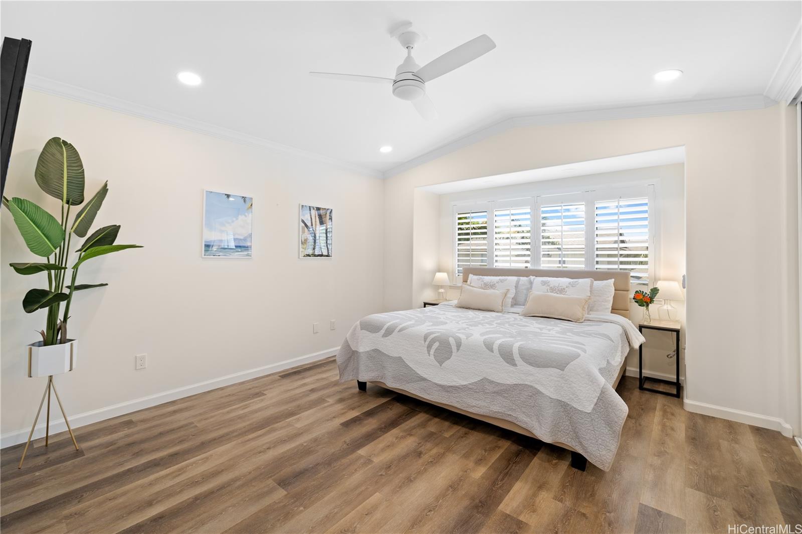 a bedroom with a bed lamp and a potted plant