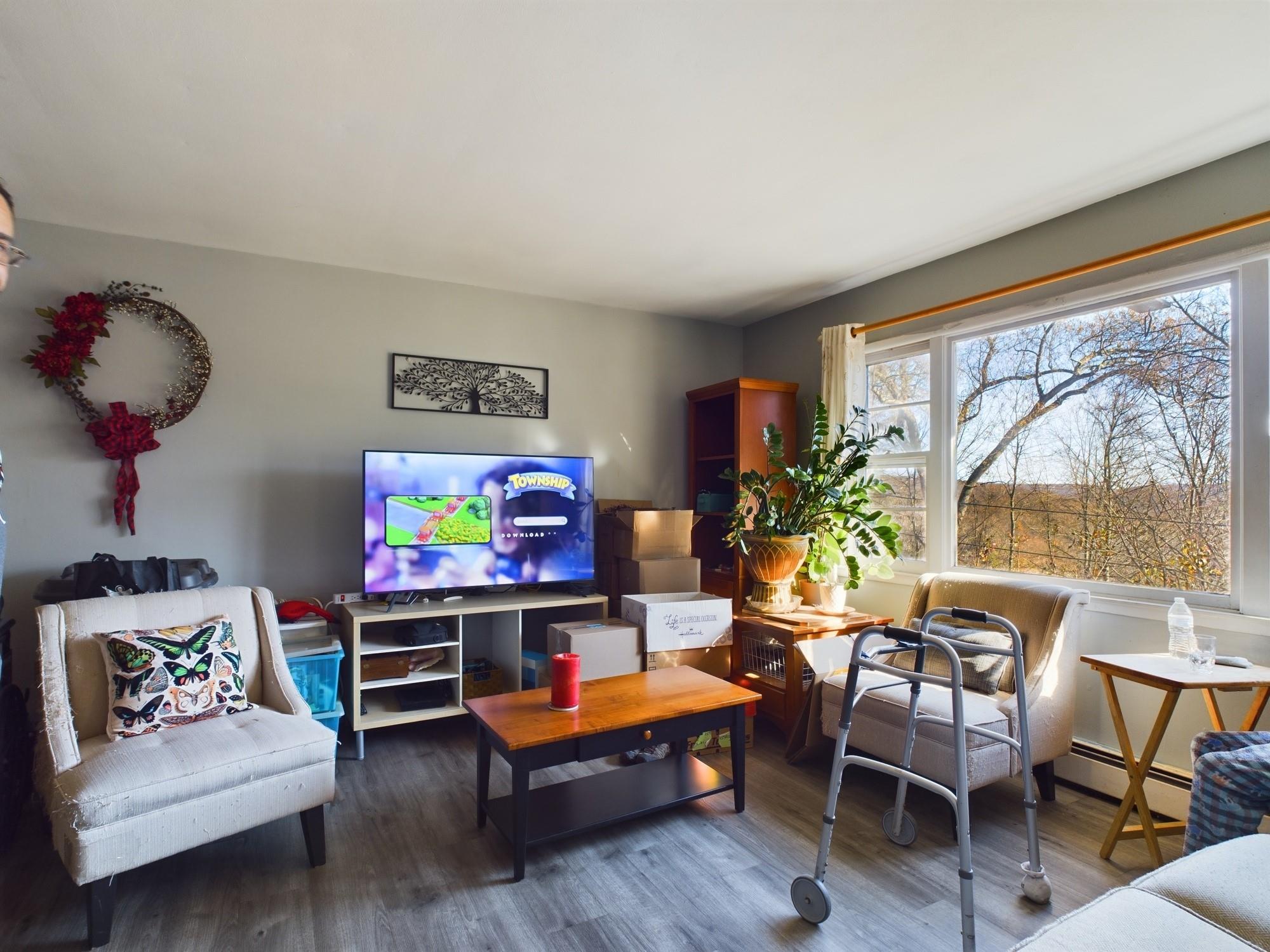 Living room featuring baseboard heating and hardwood / wood-style flooring