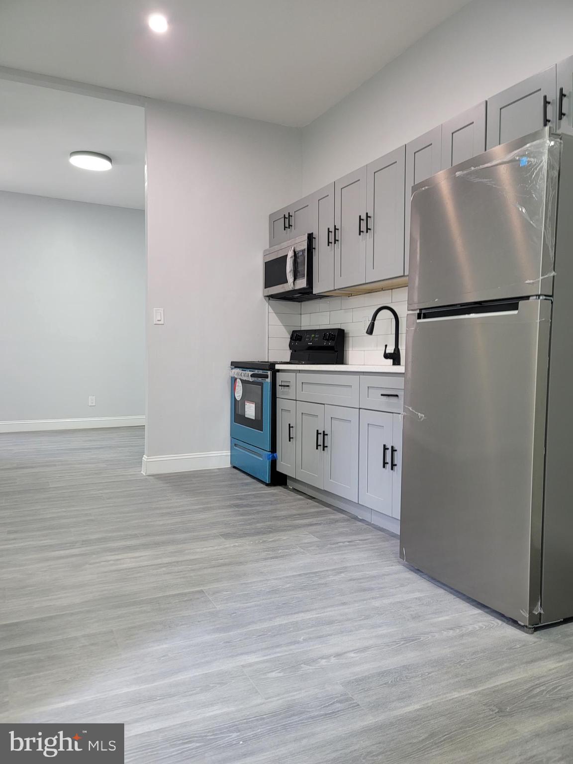 a kitchen with stainless steel appliances a refrigerator sink and cabinets