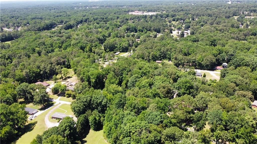 an aerial view of residential house with outdoor space and trees all around