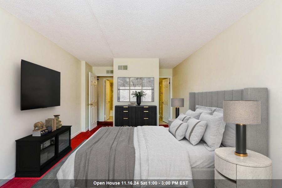 a bedroom with a bed and a flat tv screen on the dresser