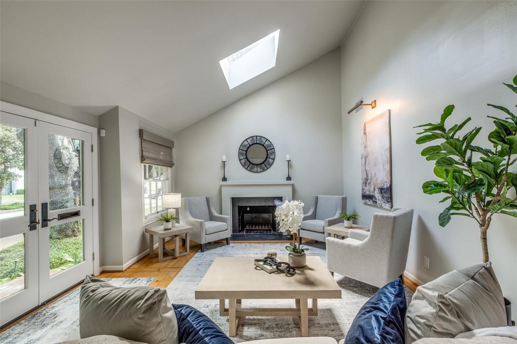 a living room with furniture fireplace and a large window