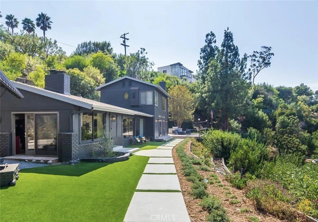 a front view of a house with a yard and potted plants