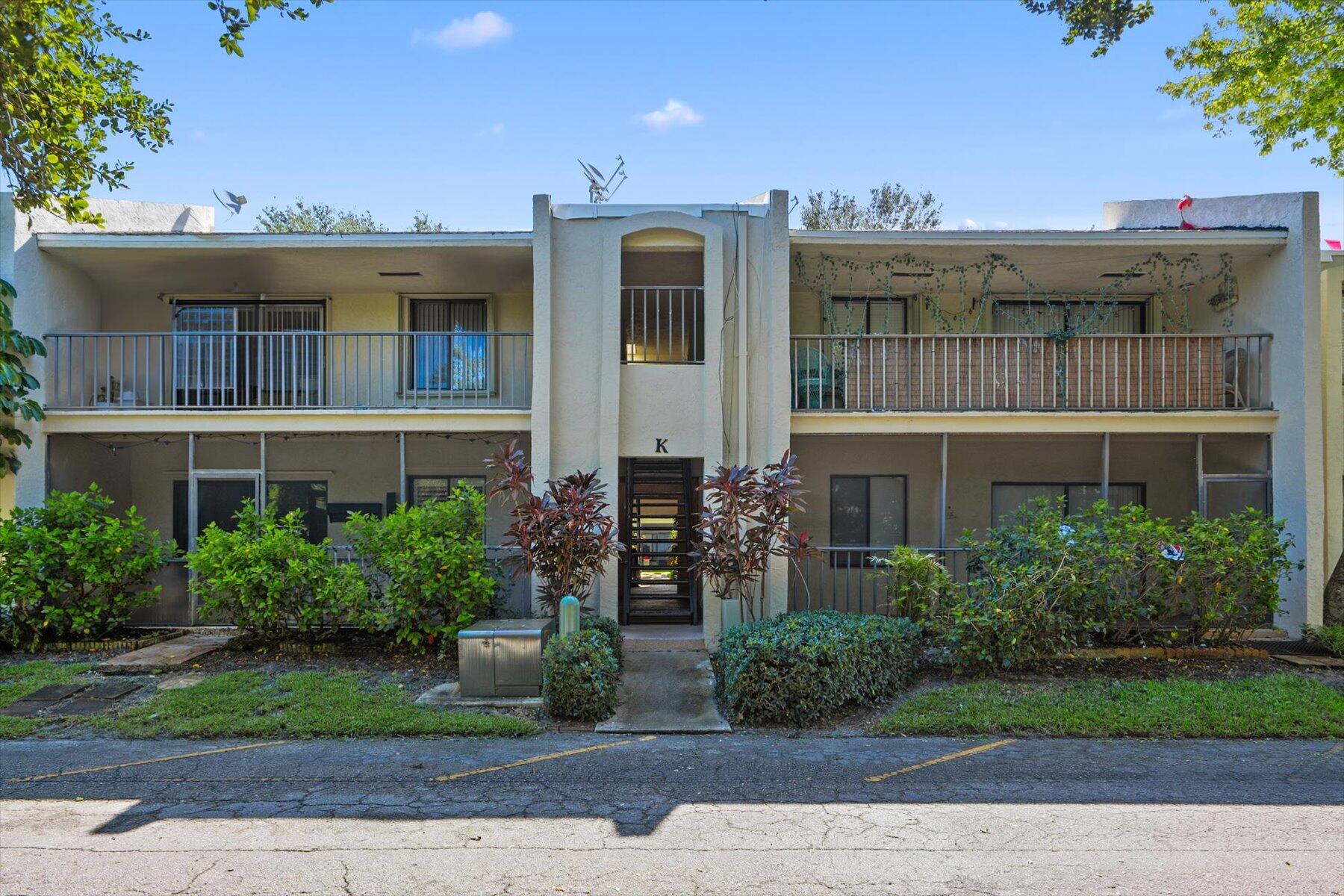 a front view of multi story residential apartment building with a yard