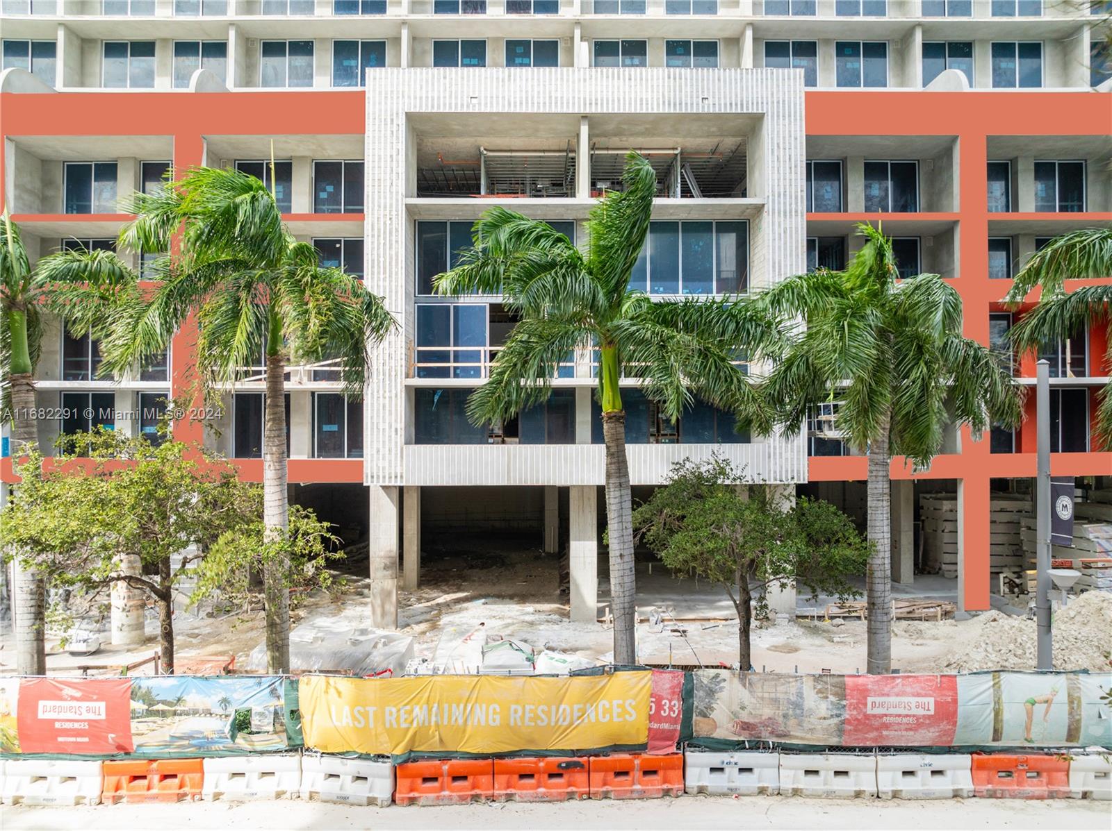 a view of tall building with large windows and plants