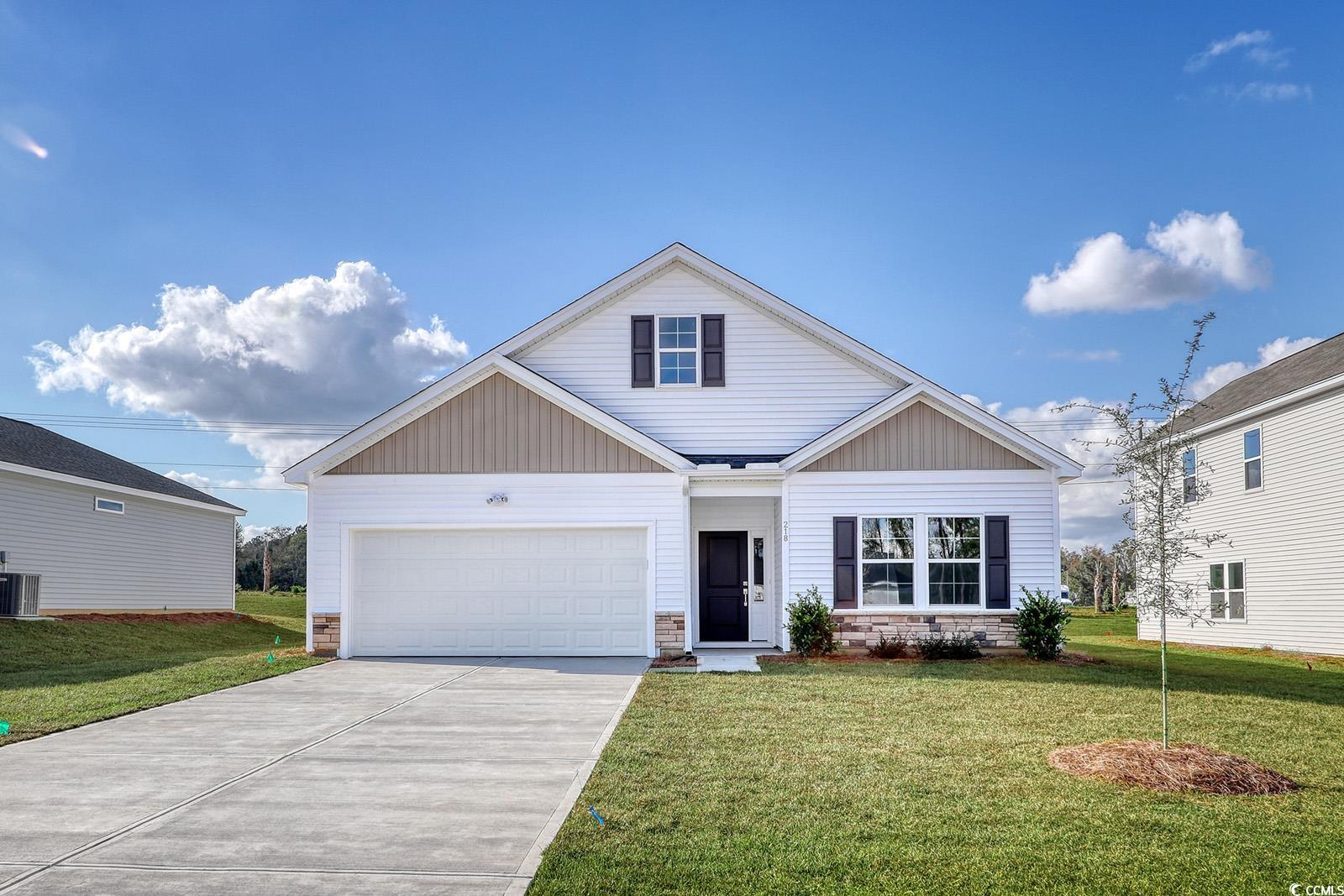 View of front of house with a front yard, a garage