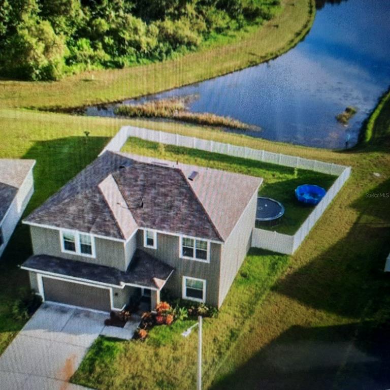 an aerial view of a house with swimming pool and garden