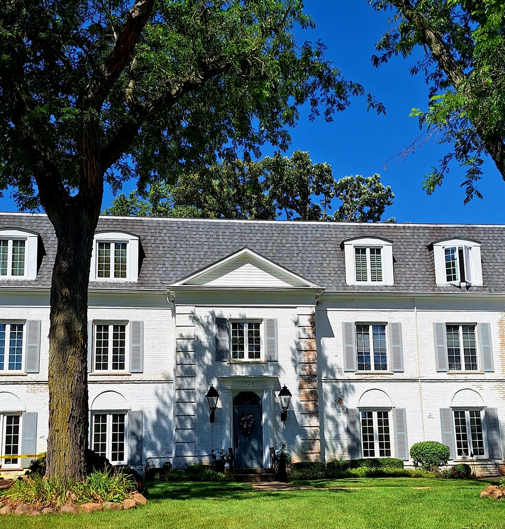 a front view of residential houses with yard and green space