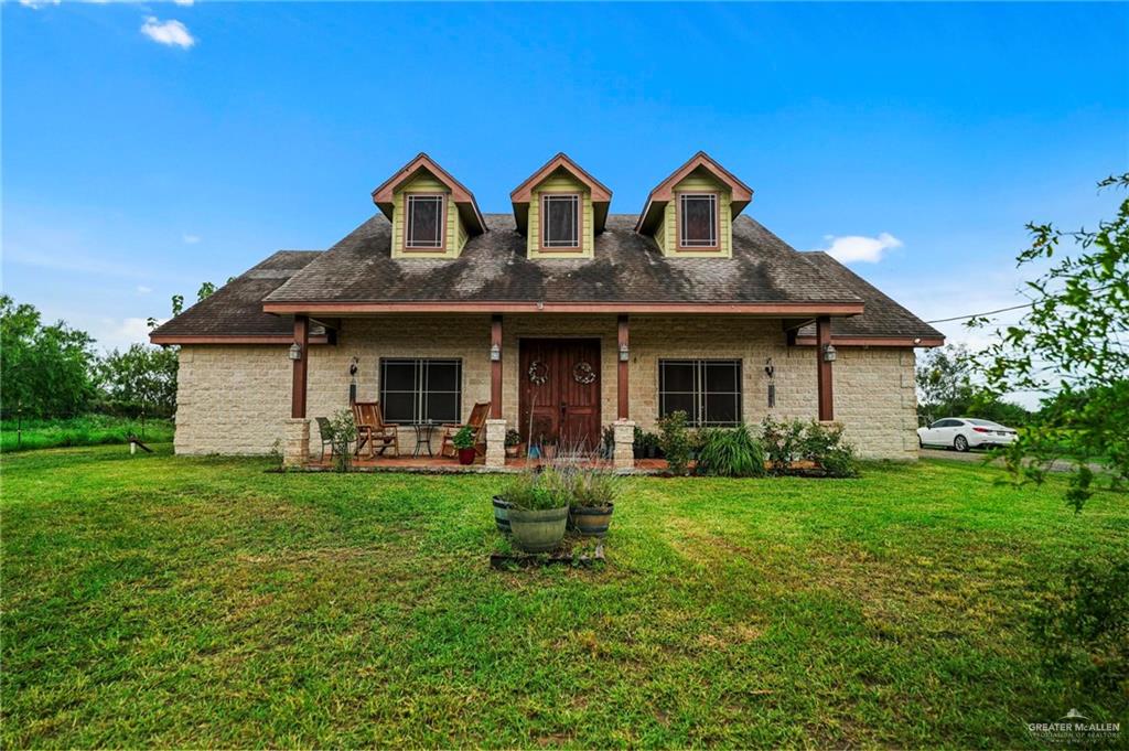 a front view of a house with backyard garden and outdoor seating