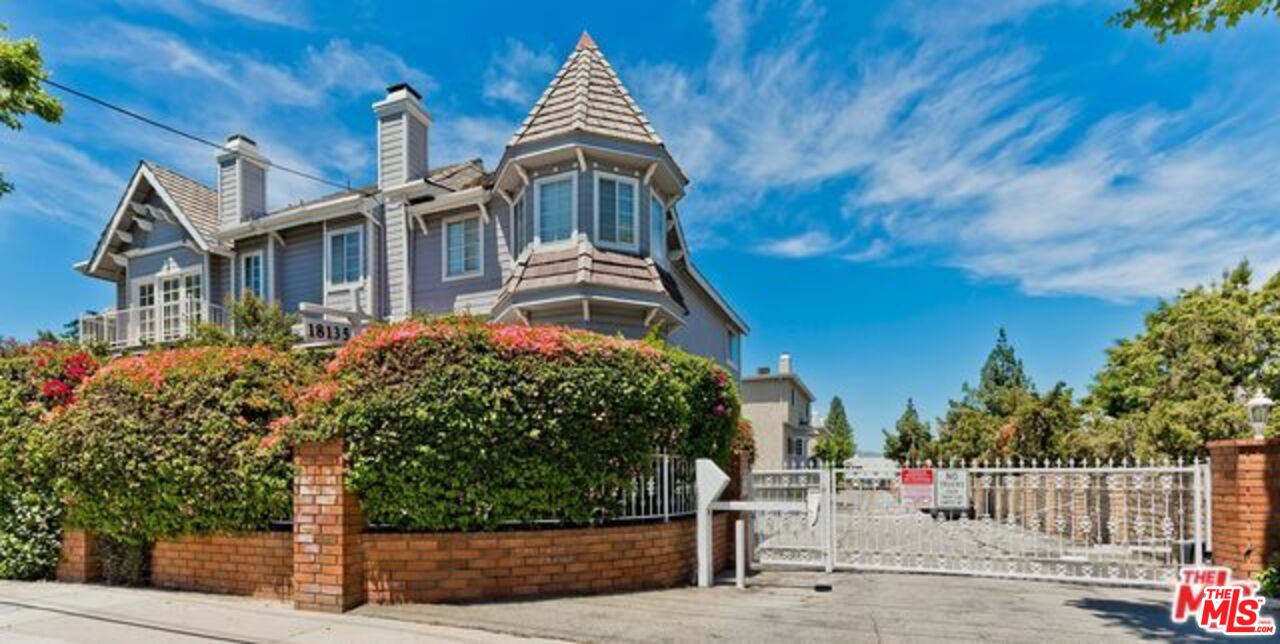 a front view of a house with a tree