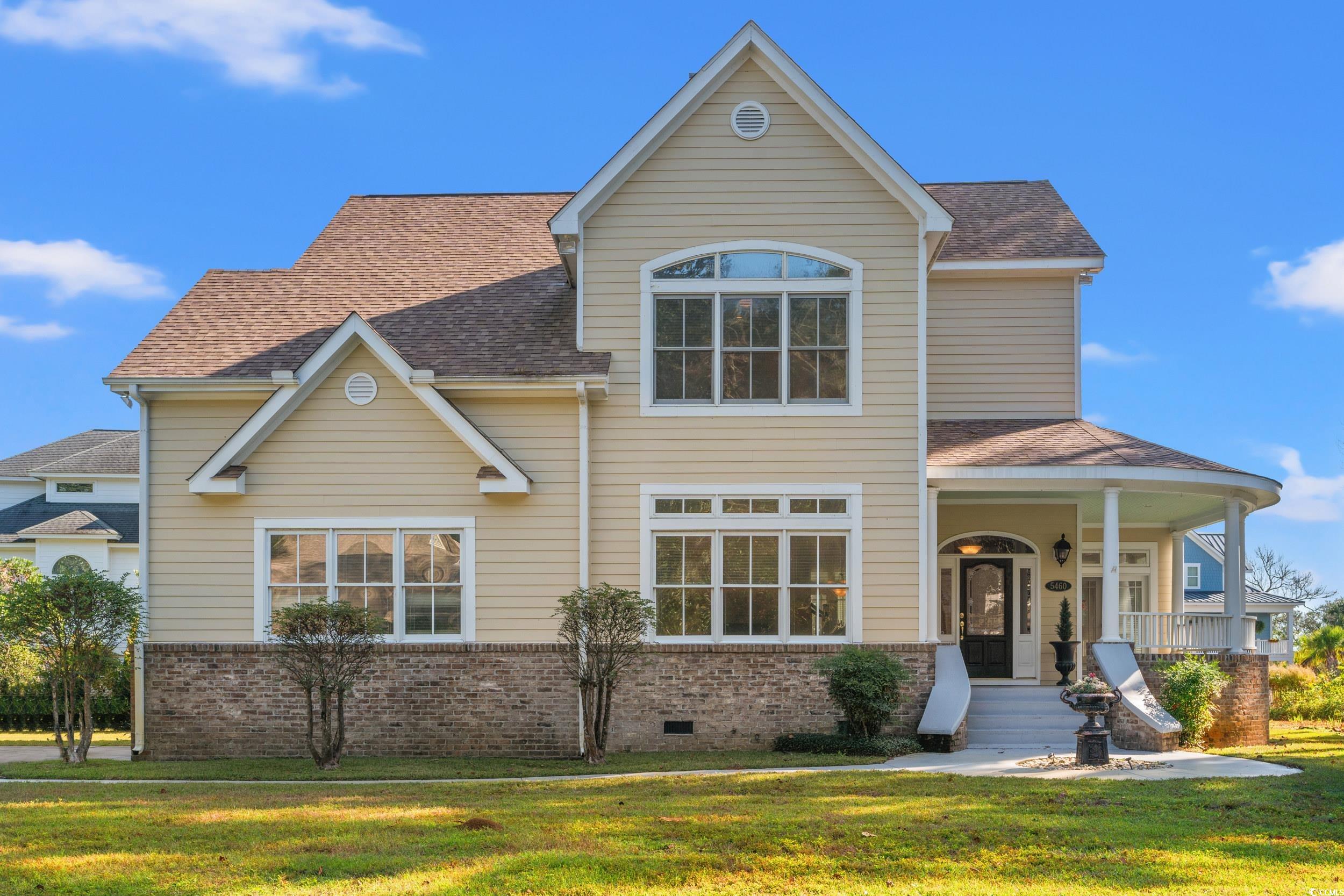 Front of property with covered porch and a front y