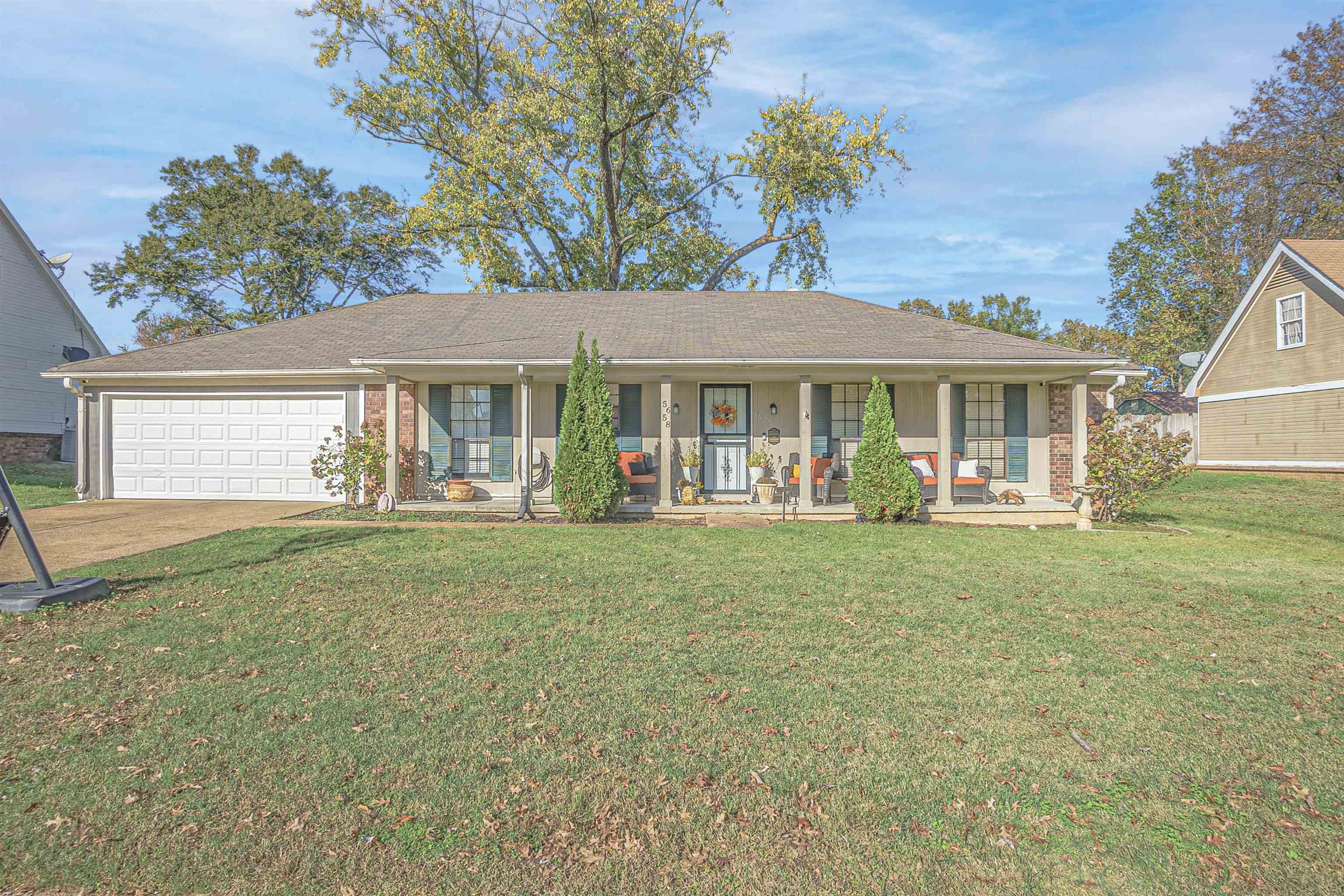 Single story home with a garage, covered porch, and a front yard