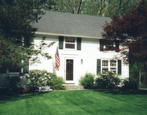 a front view of a house with a garden and plants