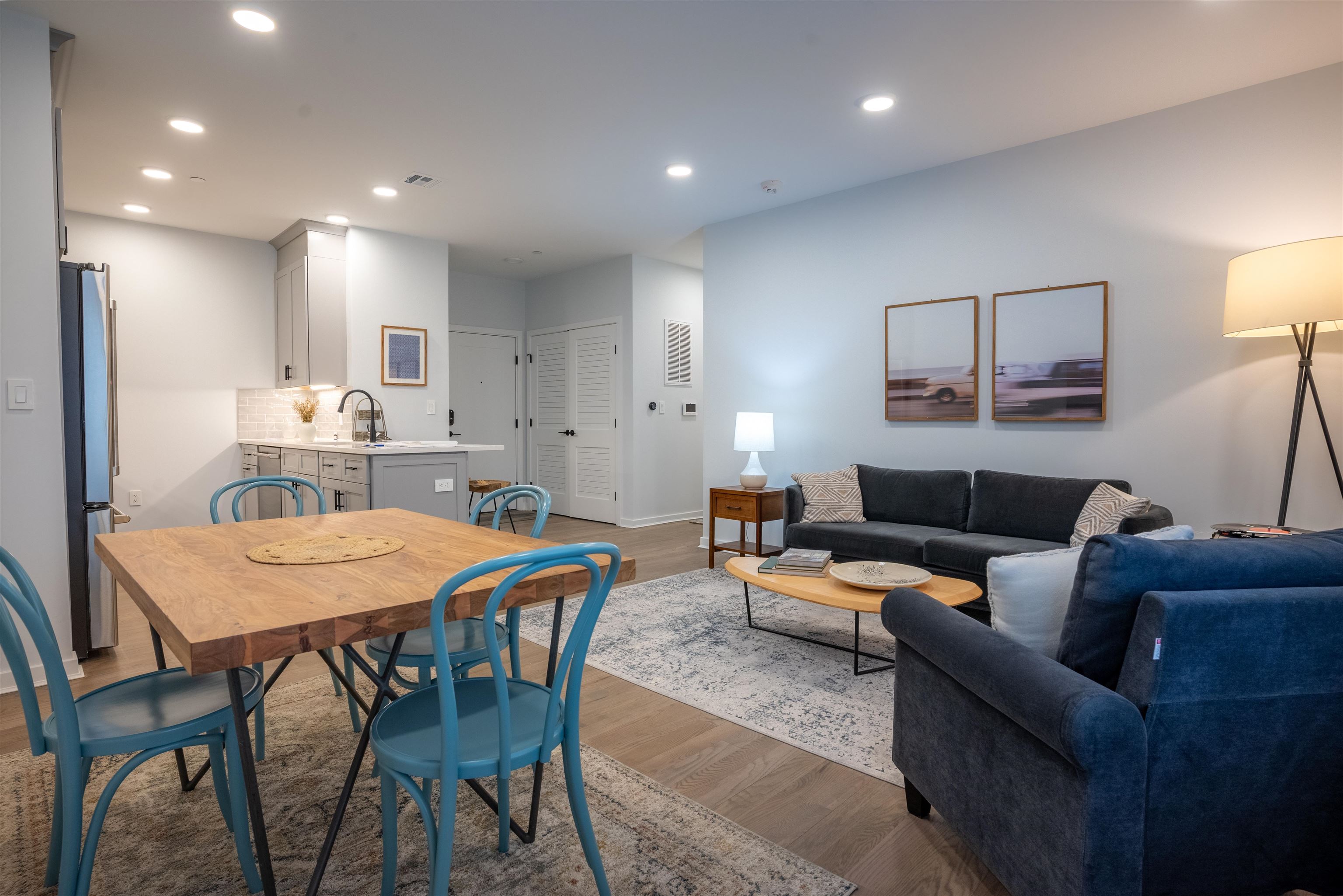 a living room with furniture and a dining table with kitchen view