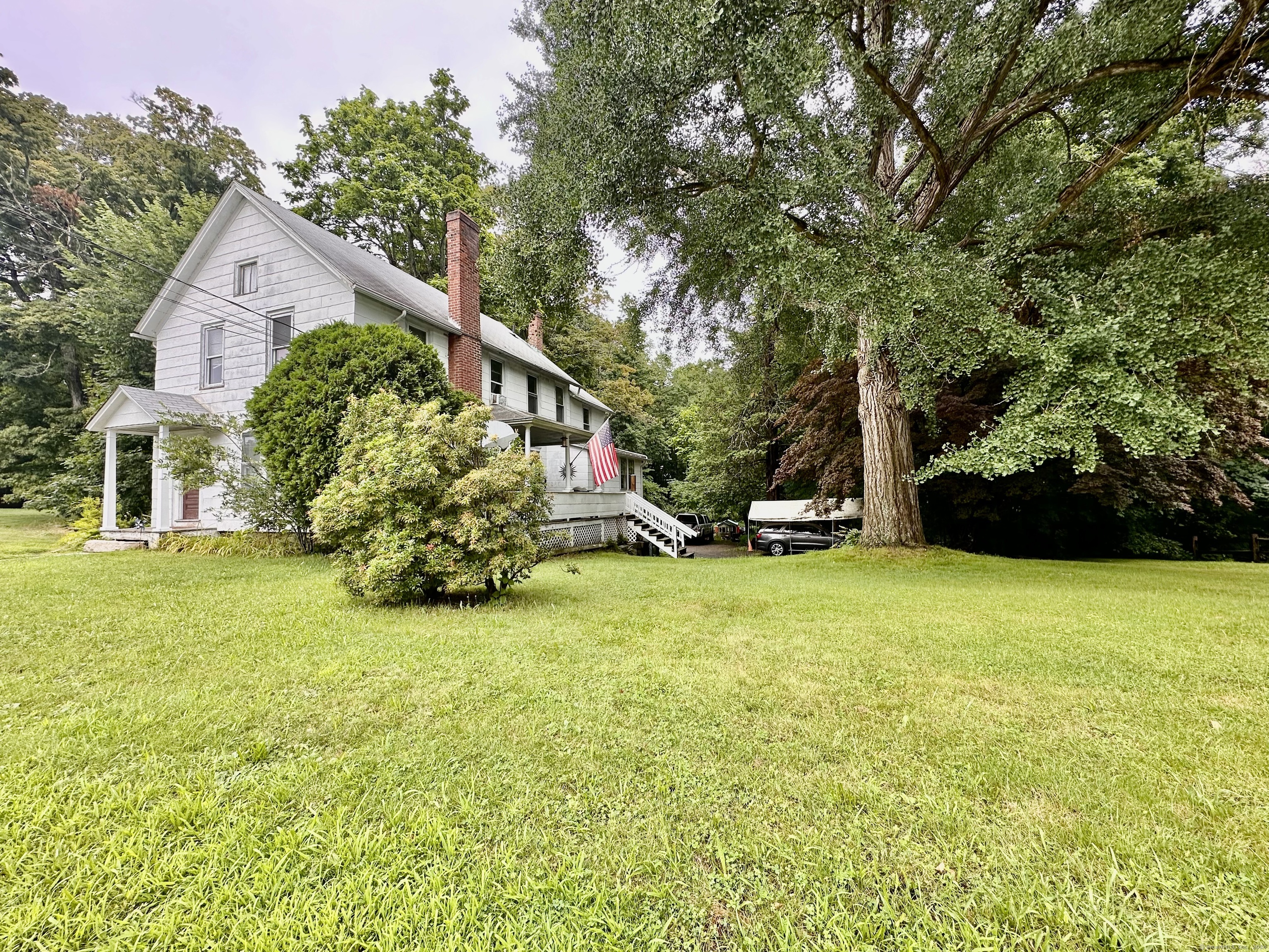 a view of a house with a yard and a wooden deck