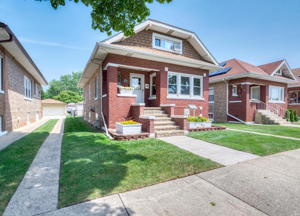 a front view of house with yard and outdoor seating