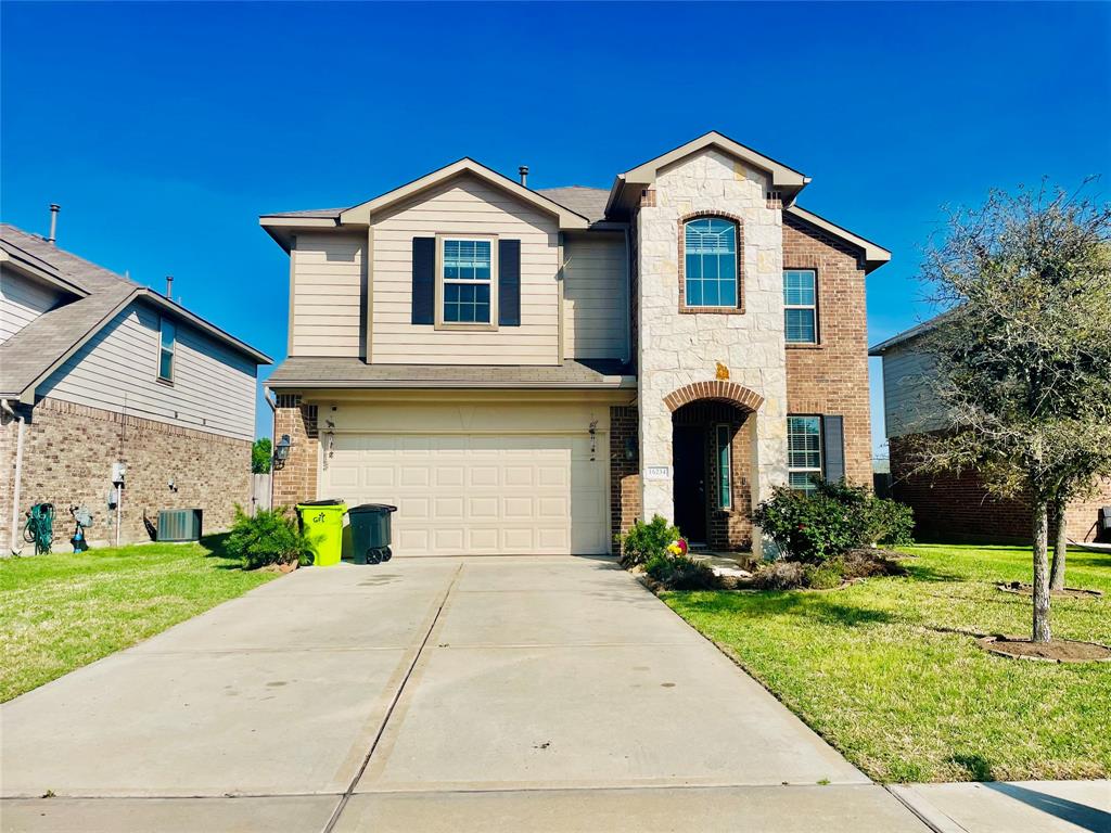 a front view of a house with a yard and garage