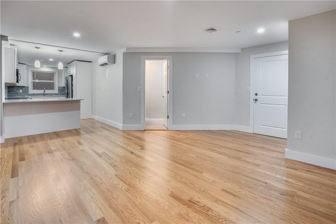 a view of a big room with wooden floor and windows