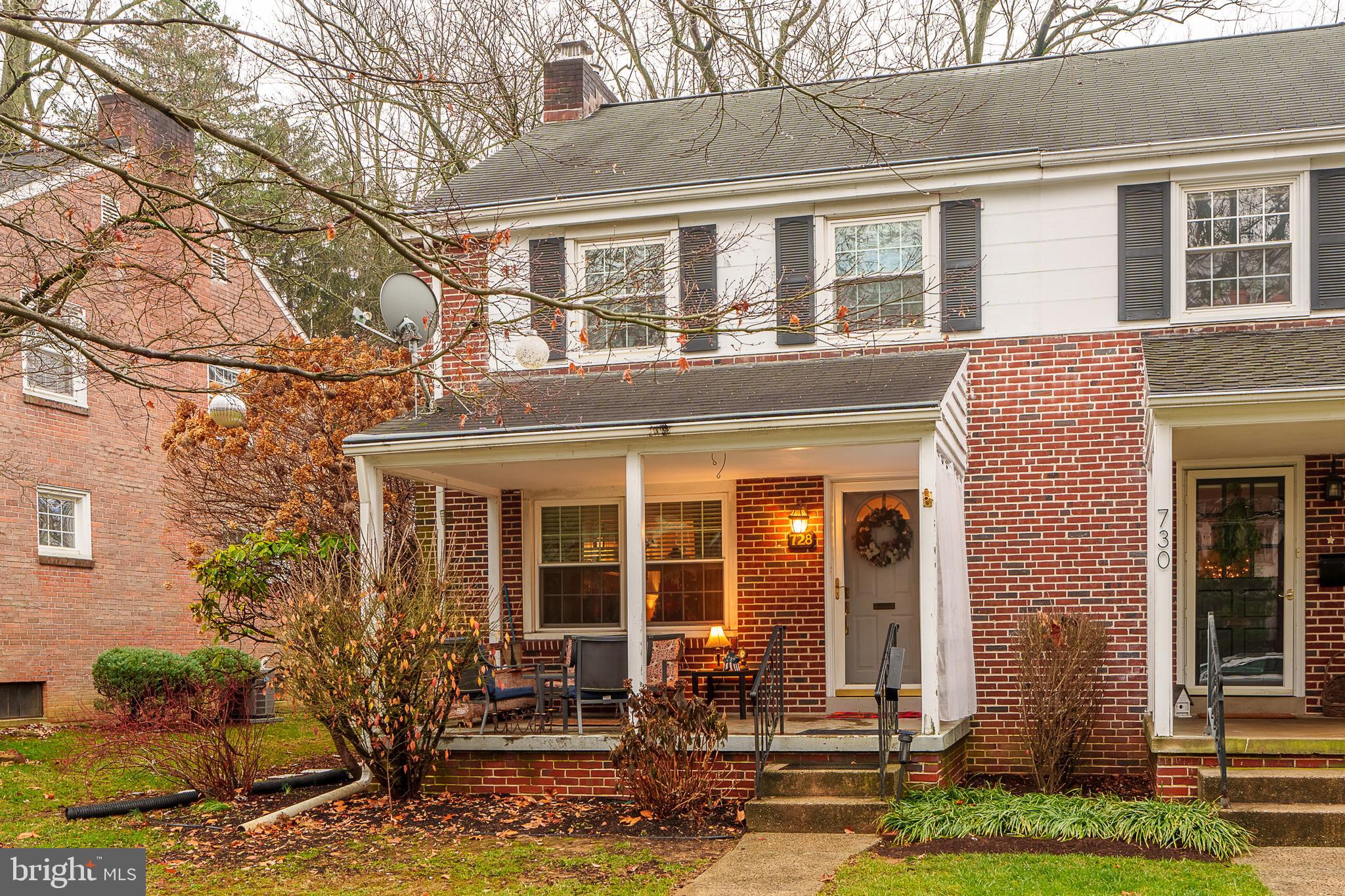 front view of a brick house with a yard