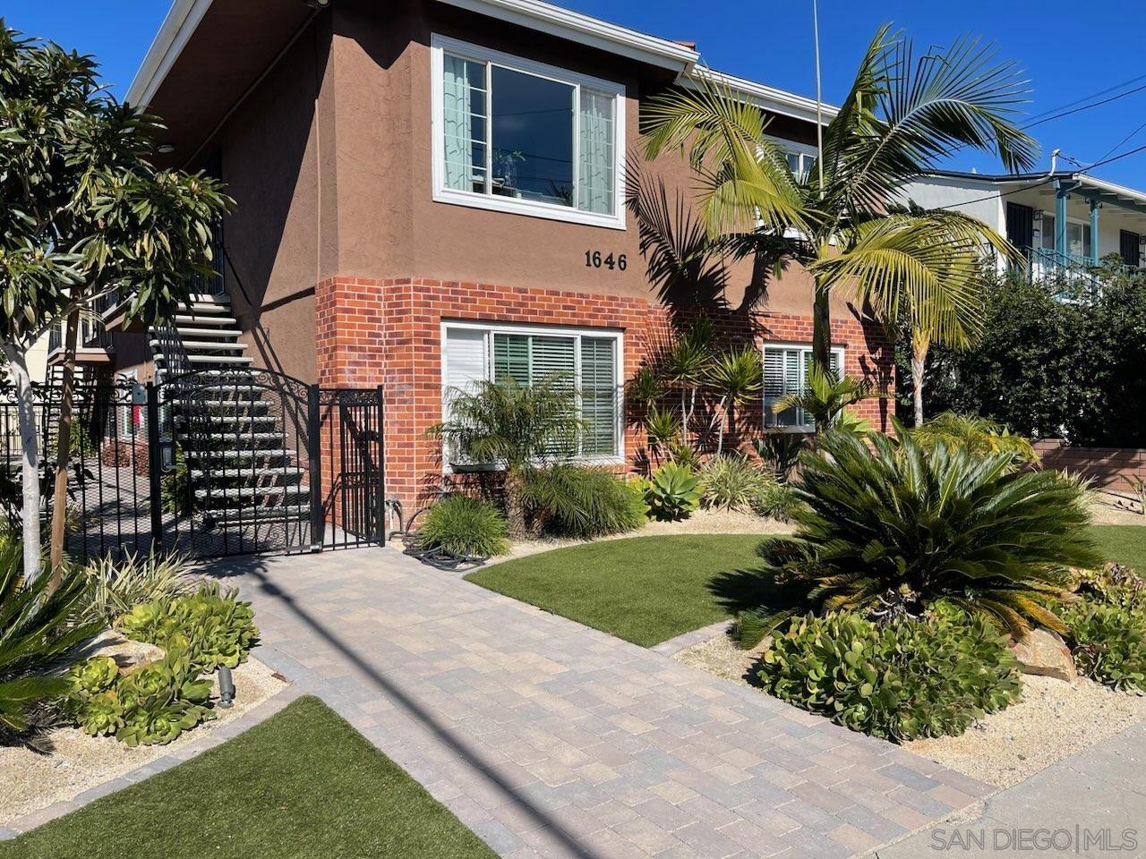 a view of a house with a small yard and potted plants