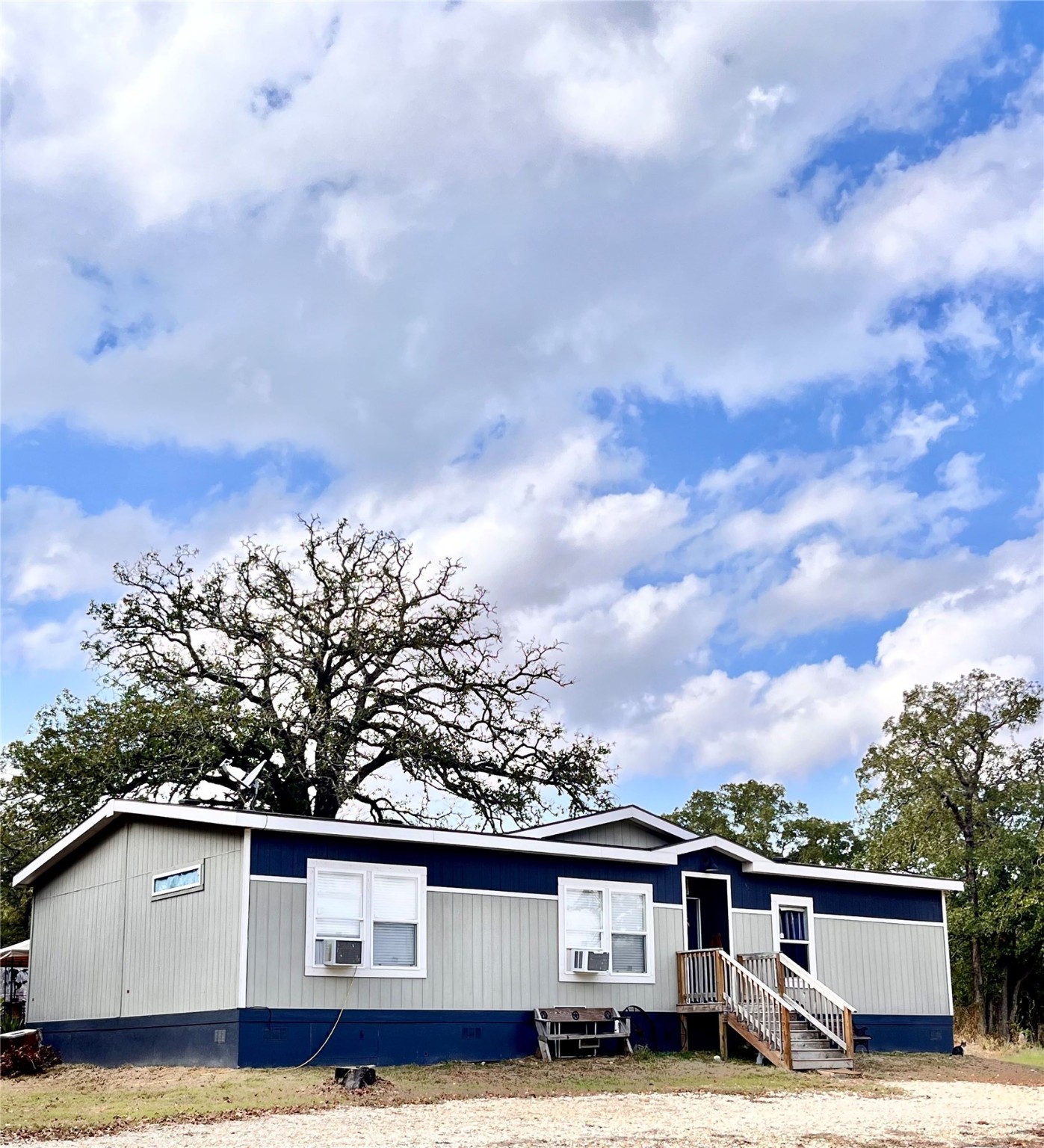 a view of a house with a big yard and large trees