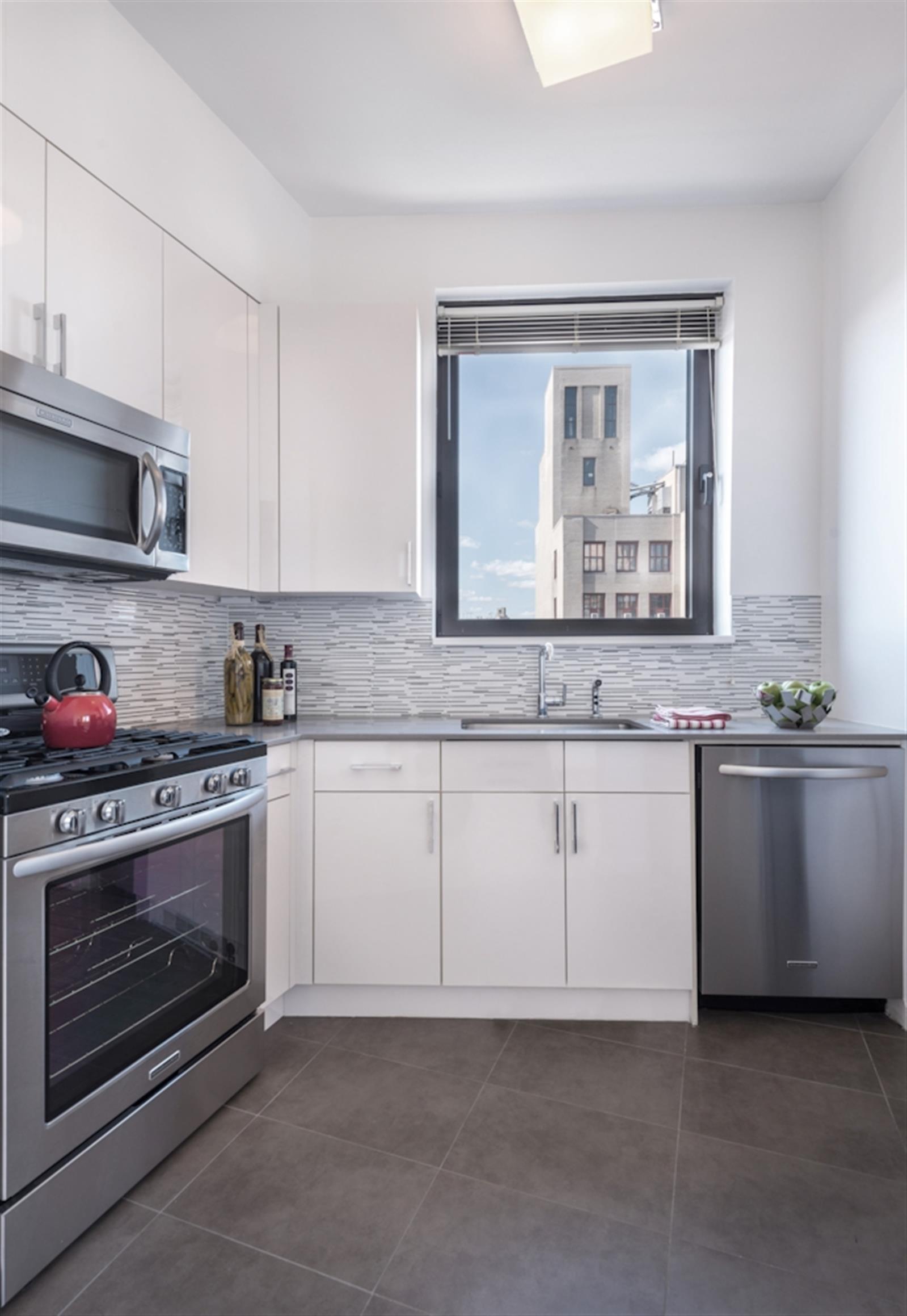 a kitchen with granite countertop white cabinets stainless steel appliances and sink