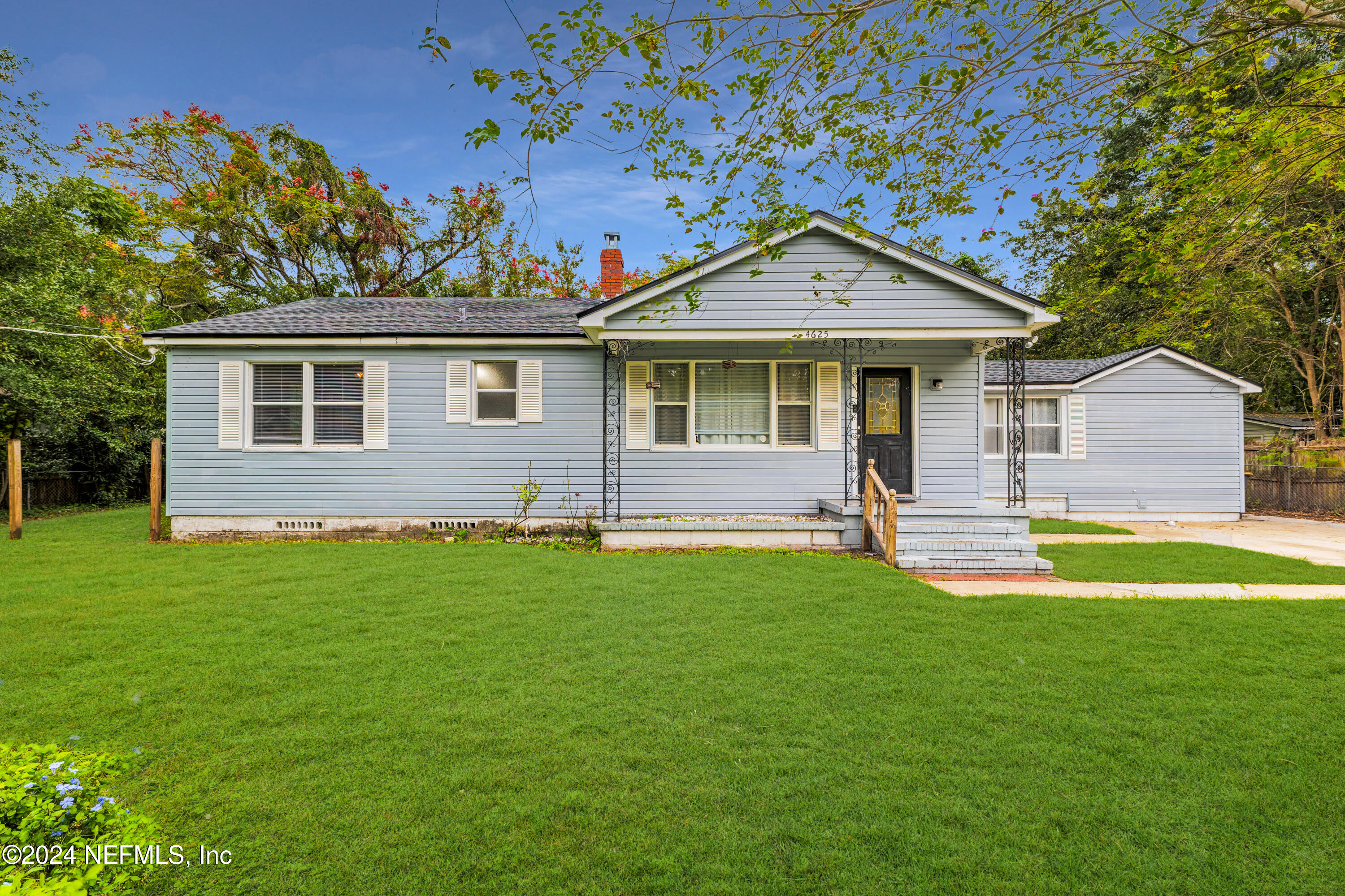 a front view of a house with yard and green space