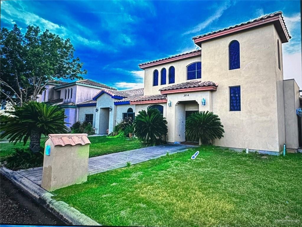 a front view of a house with a yard and trees