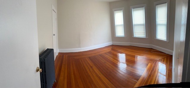 a view of empty room with wooden floor