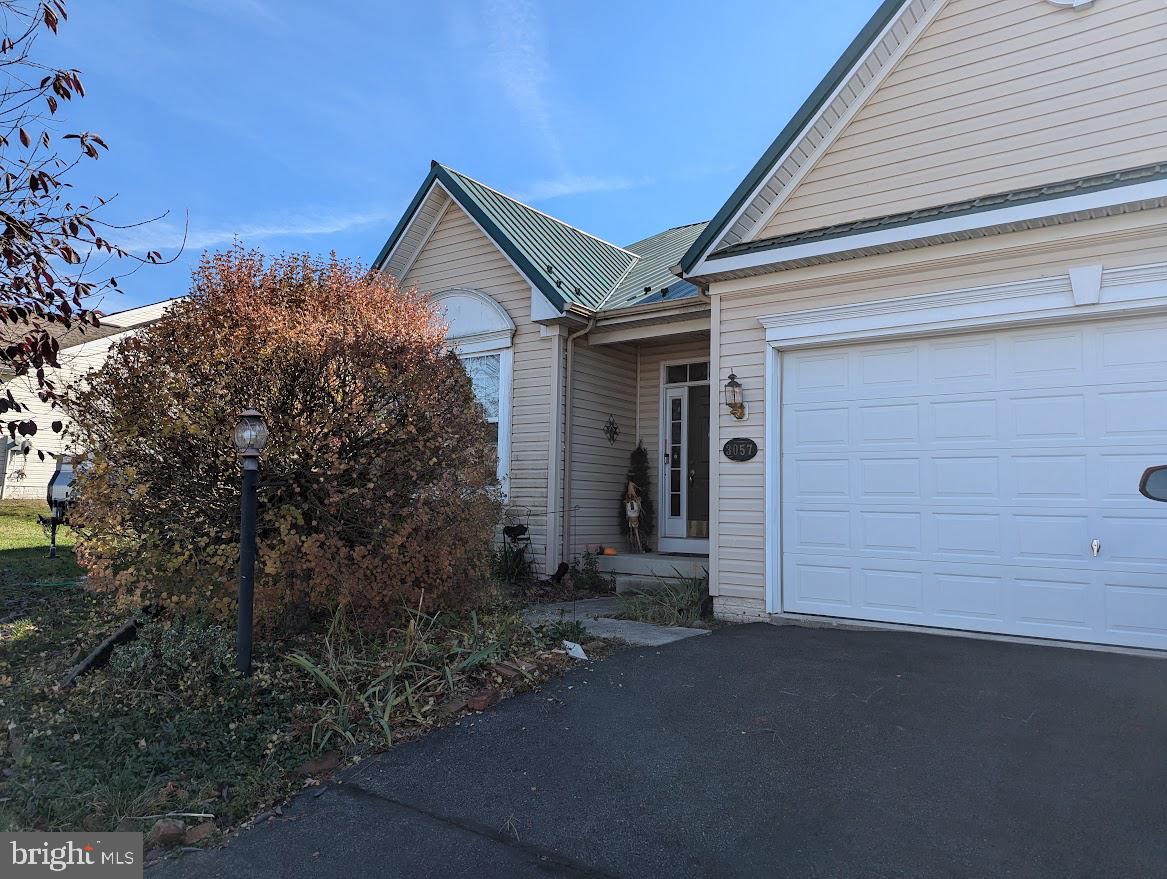 a view of a house with a small yard and garage