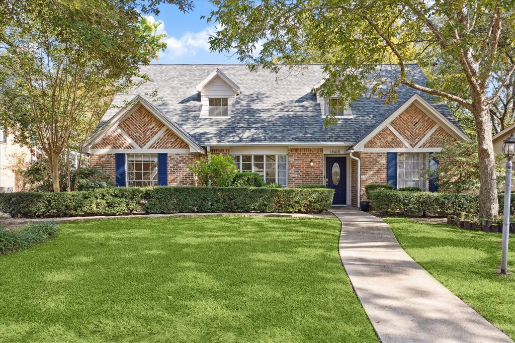 a front view of a house with a yard and trees