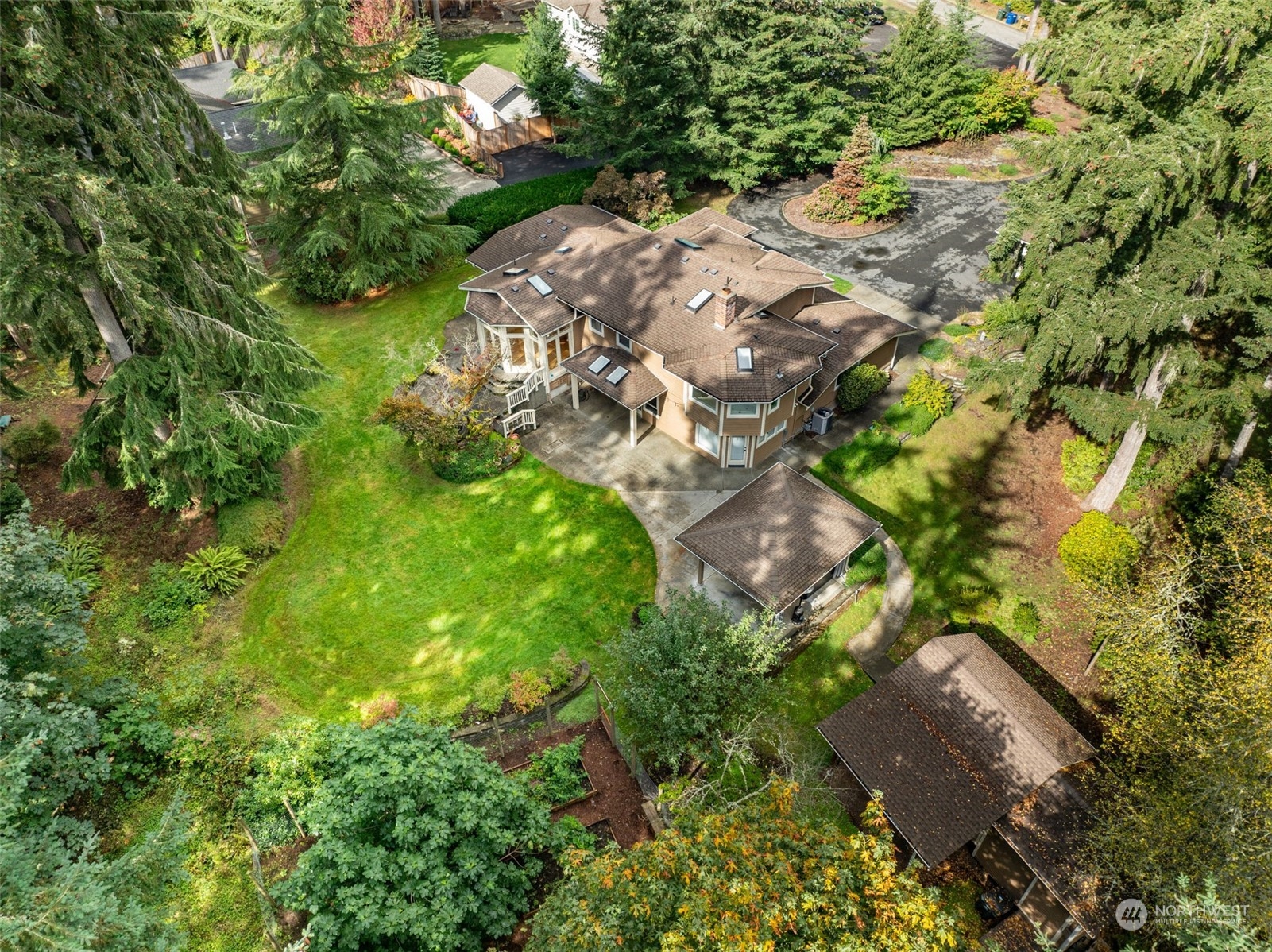 an aerial view of a house with a yard and large trees