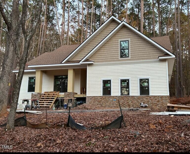 a view of a house with yard and chairs