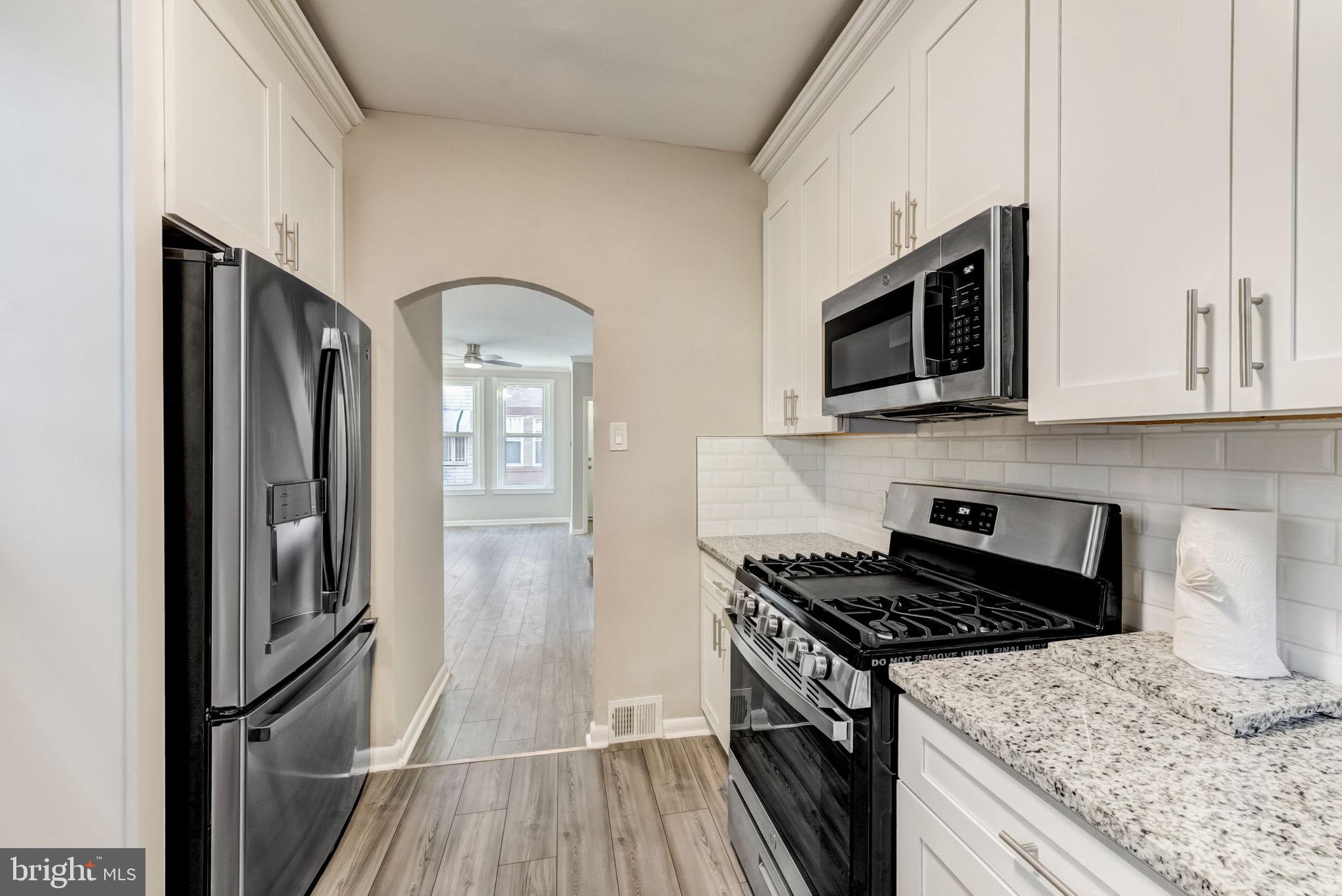 a kitchen with stainless steel appliances granite countertop a refrigerator and a stove top oven