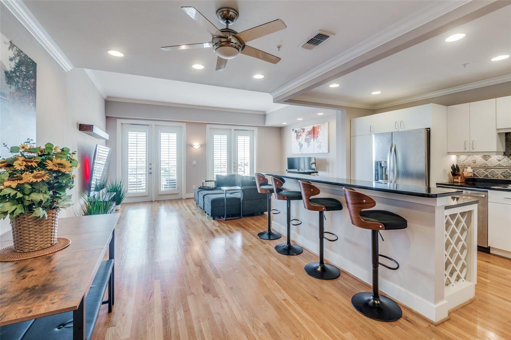 a living room with furniture potted plant kitchen view and a potted plant