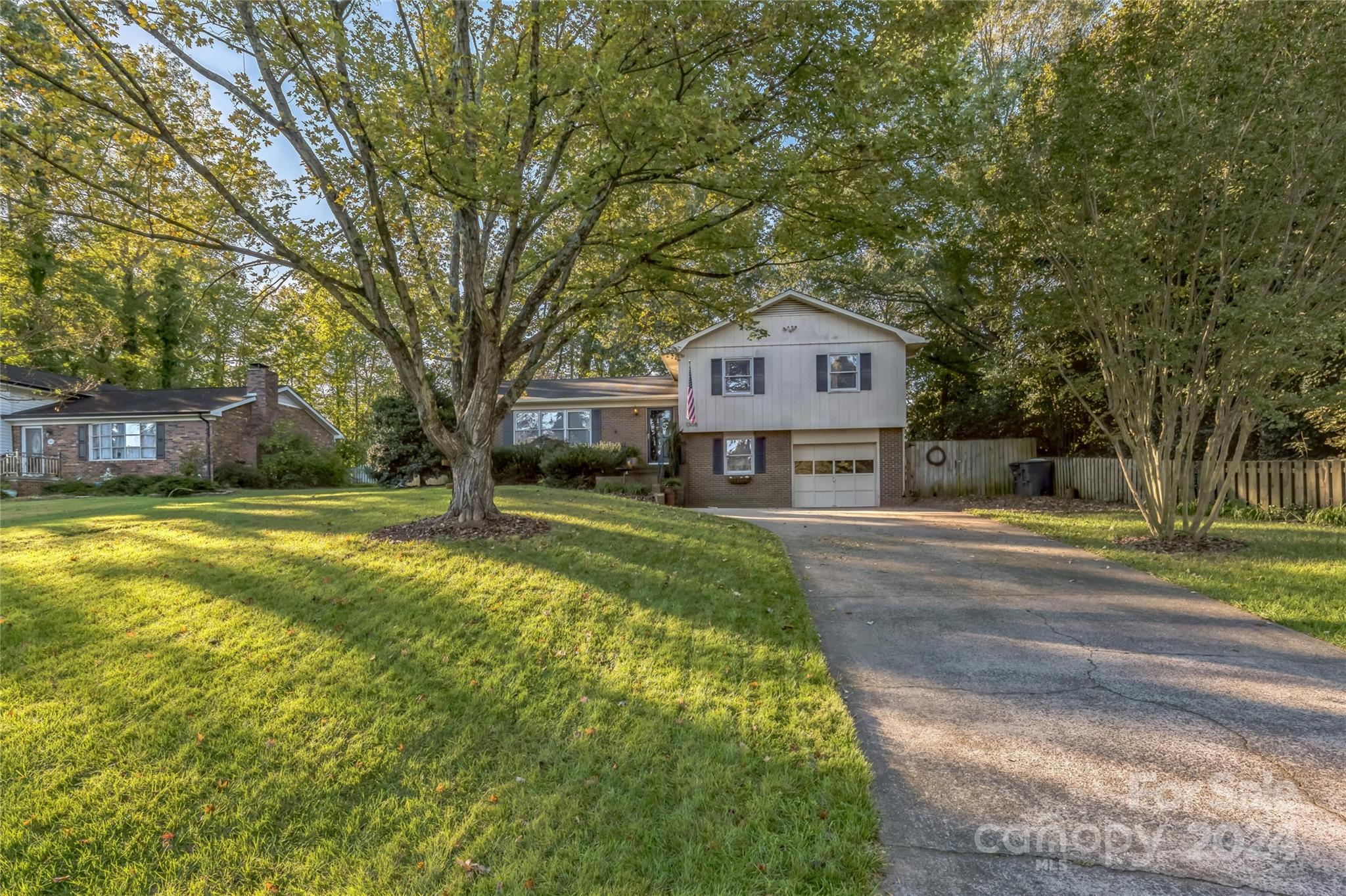 a front view of a house with a yard and large trees