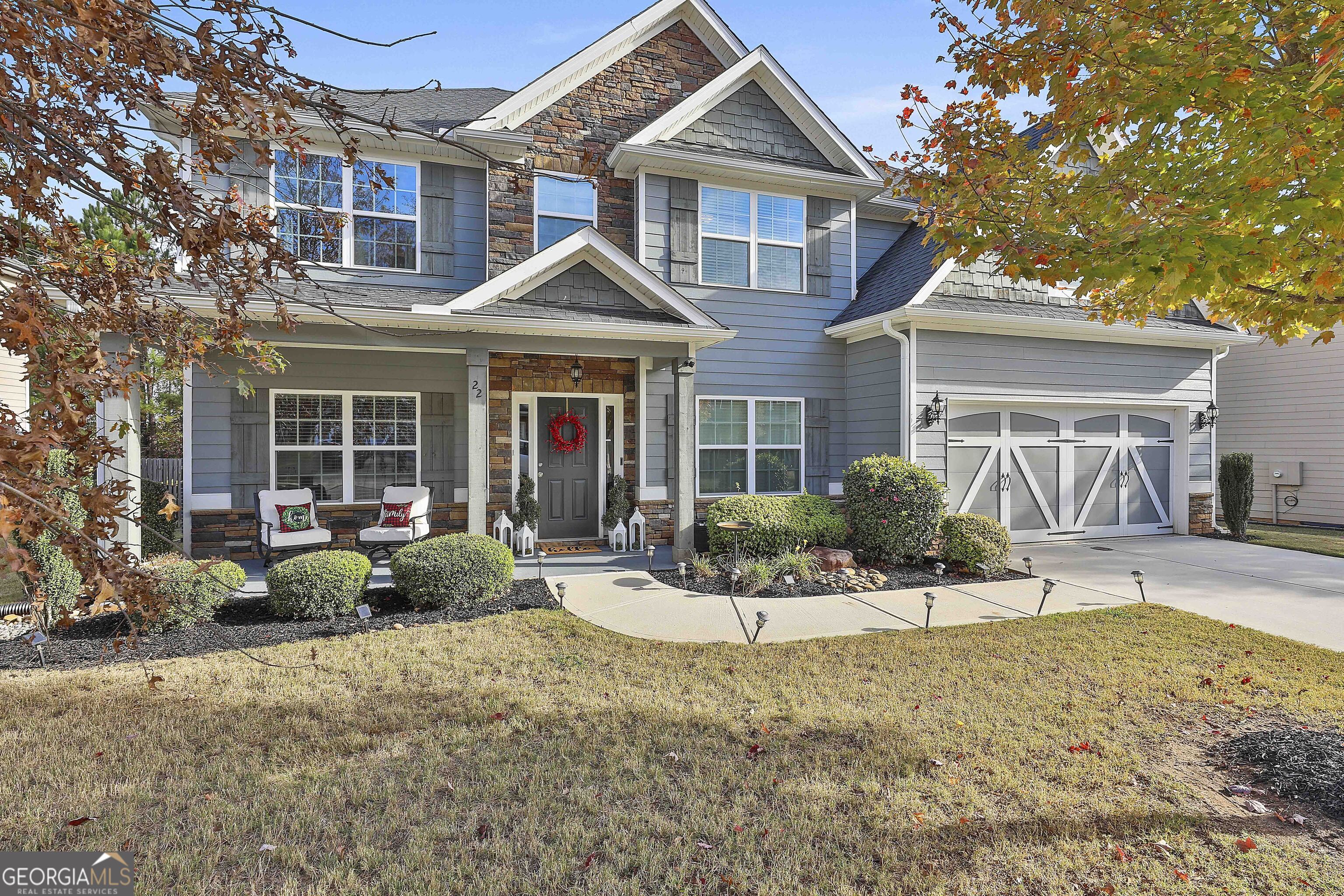 a front view of a house with a yard and potted plants