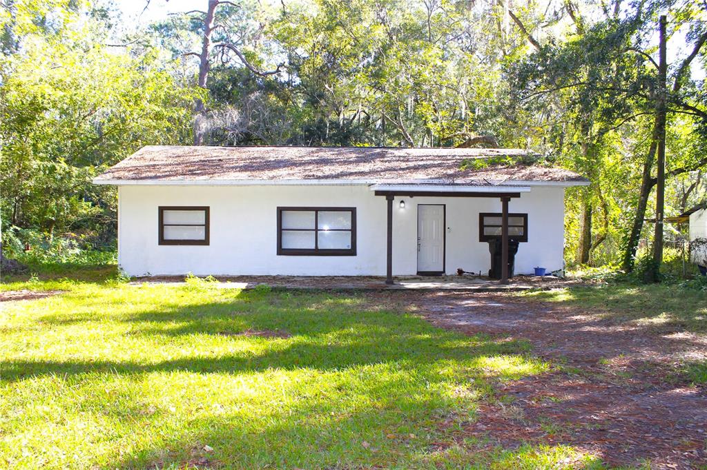 a view of a house with a yard and tree