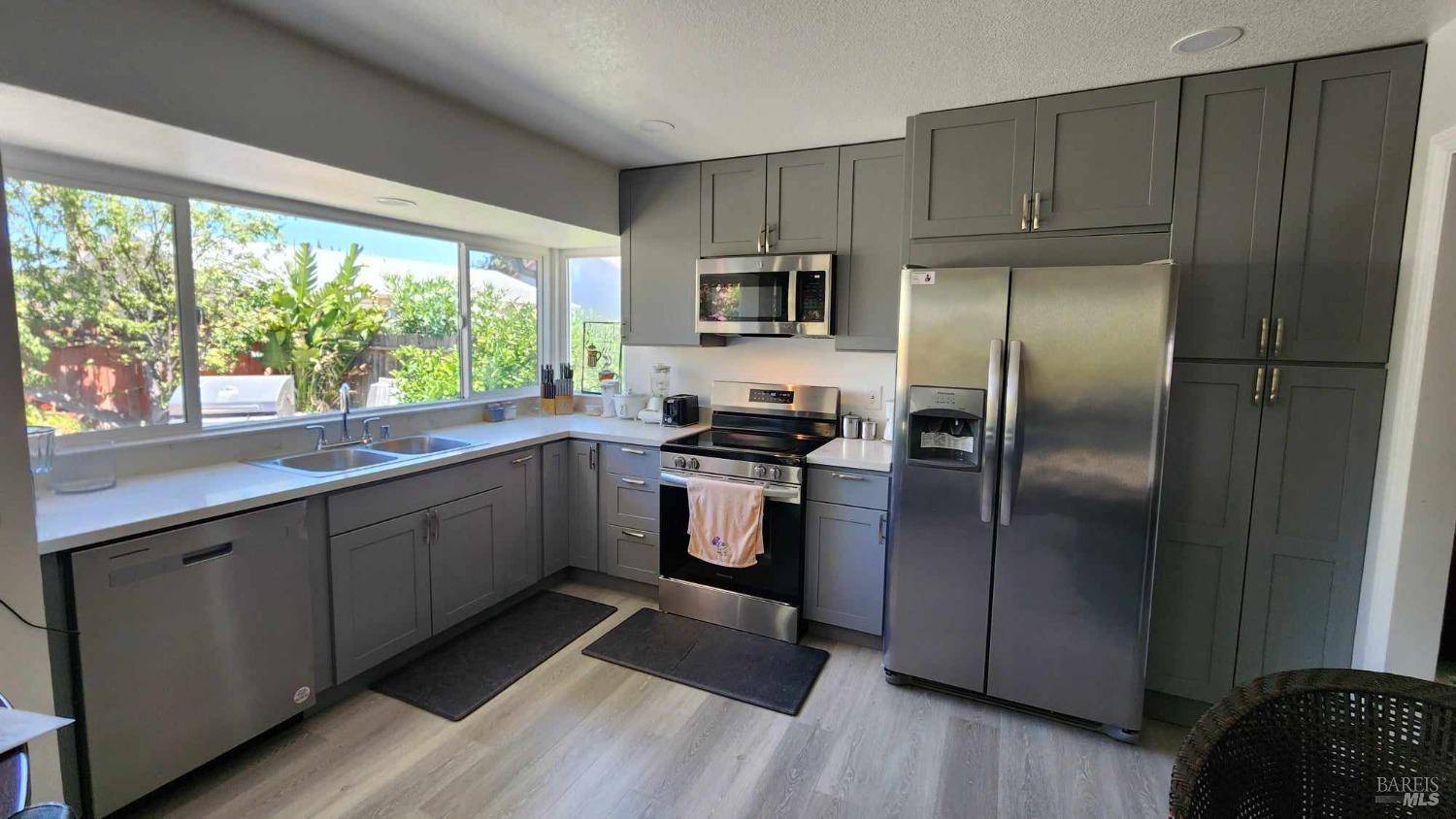 a kitchen with a refrigerator a sink and a window