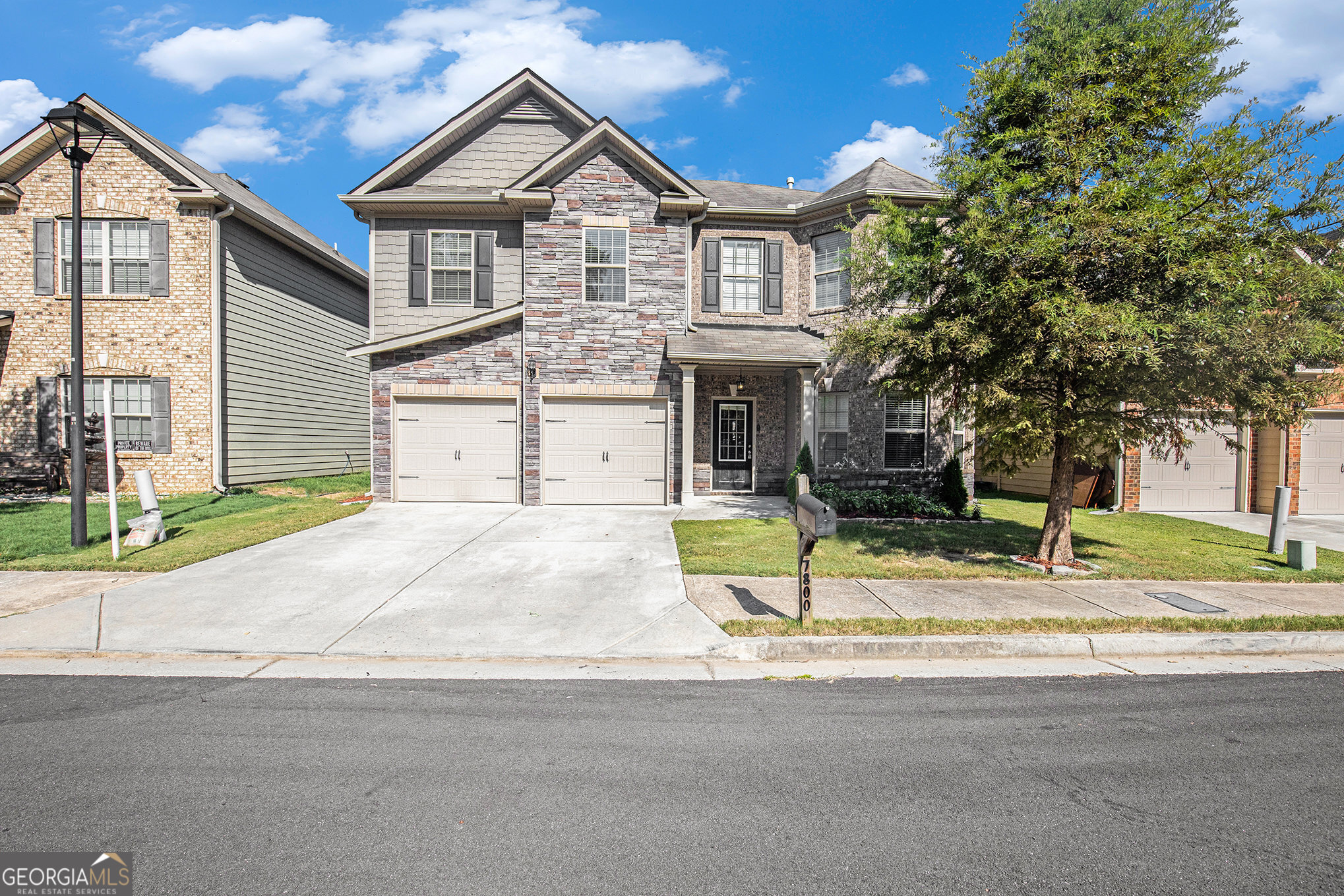 a front view of a house with a yard and garage