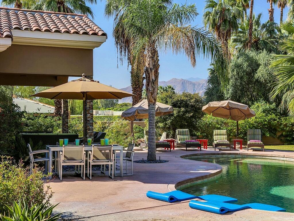 a patio with a table and chairs under an umbrella