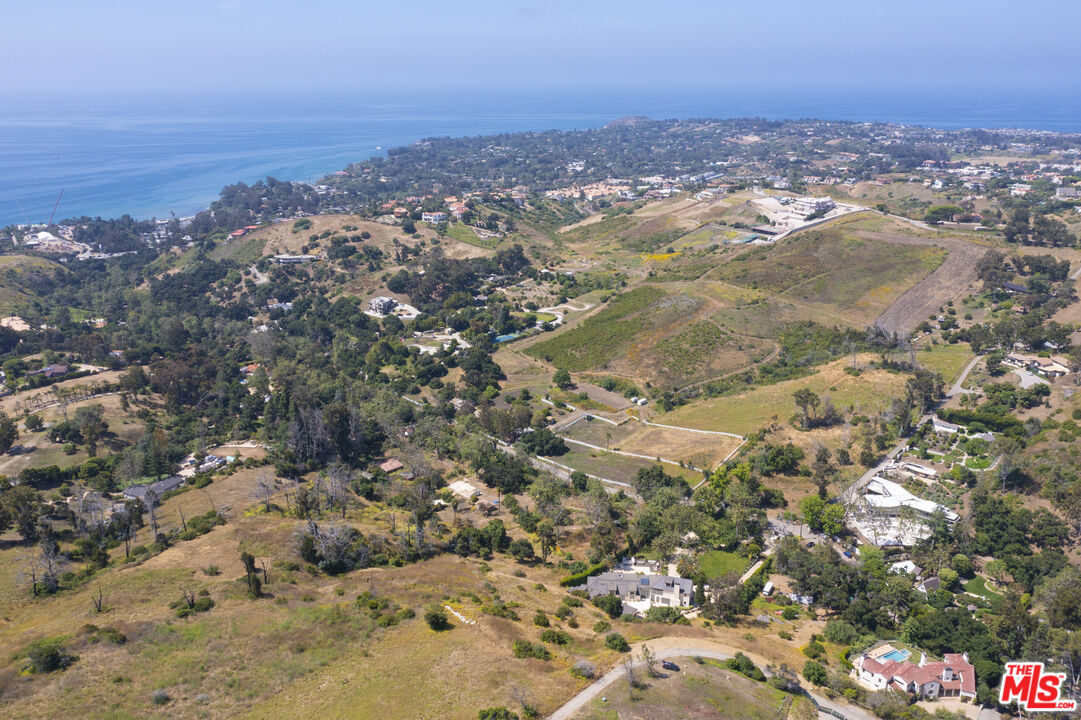 an aerial view of house with yard and mountain view in back