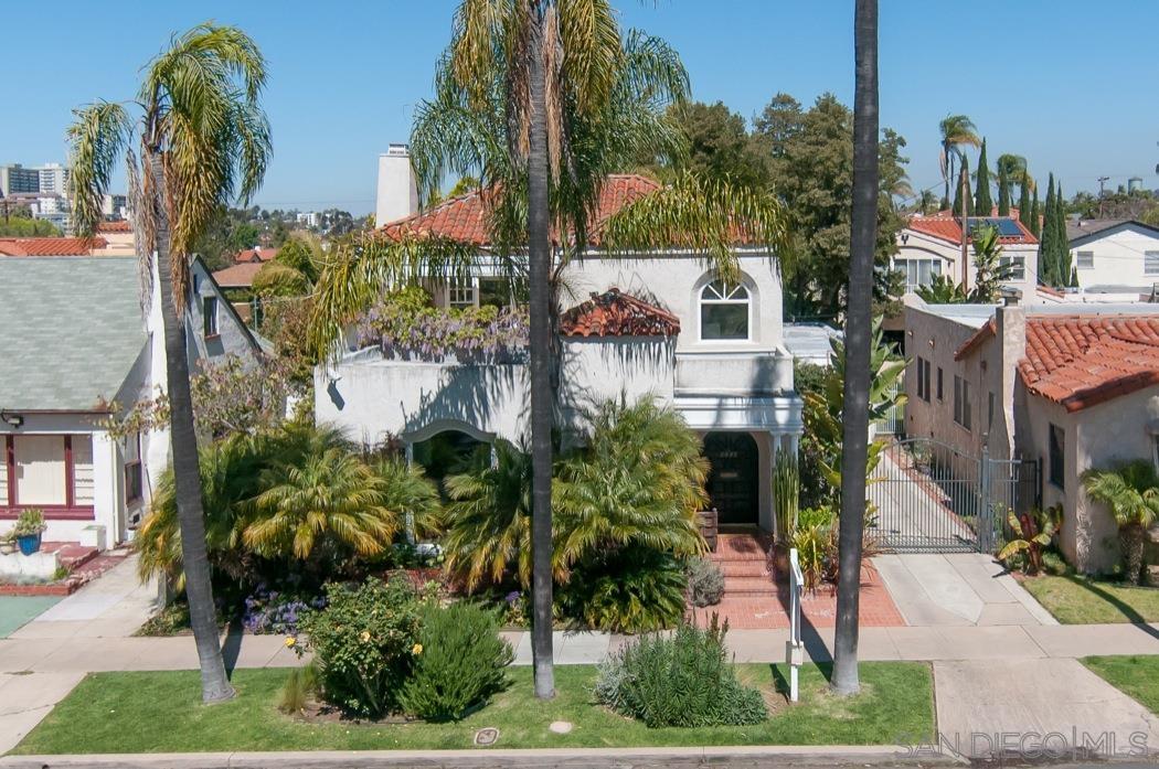 a view of a house with a yard and potted plants