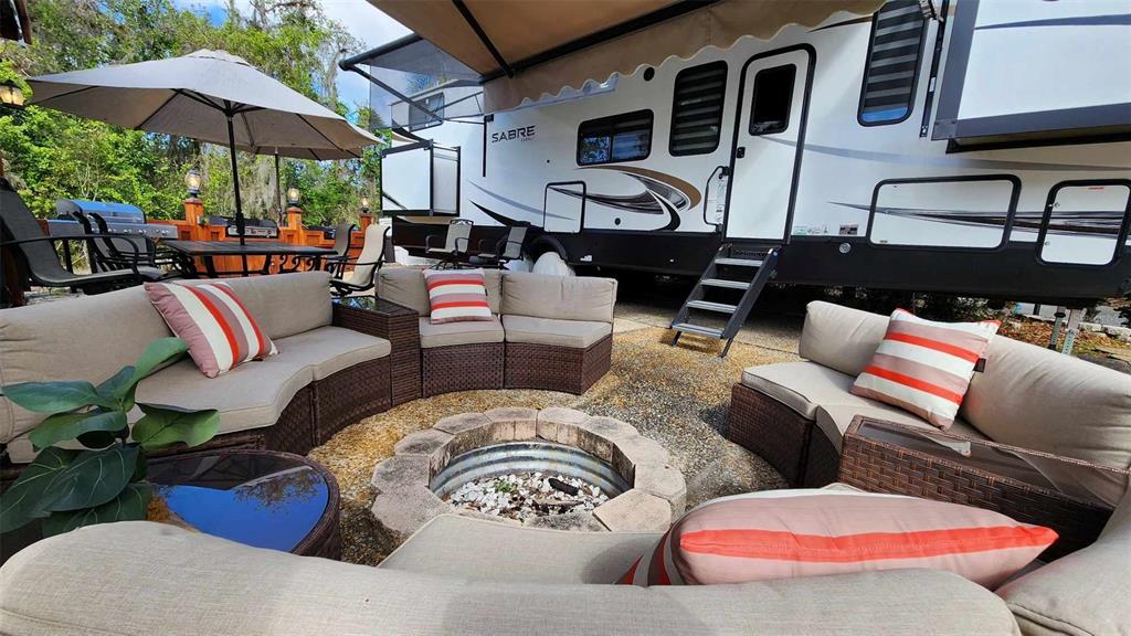 a view of a patio with couches chairs under an umbrella