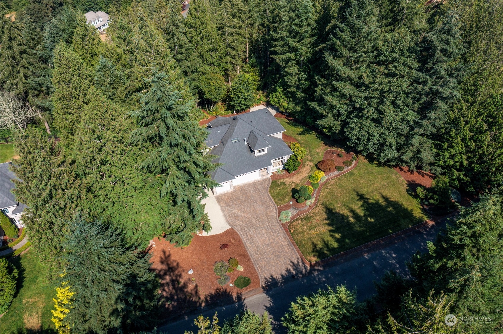 an aerial view of residential house with outdoor space and trees all around