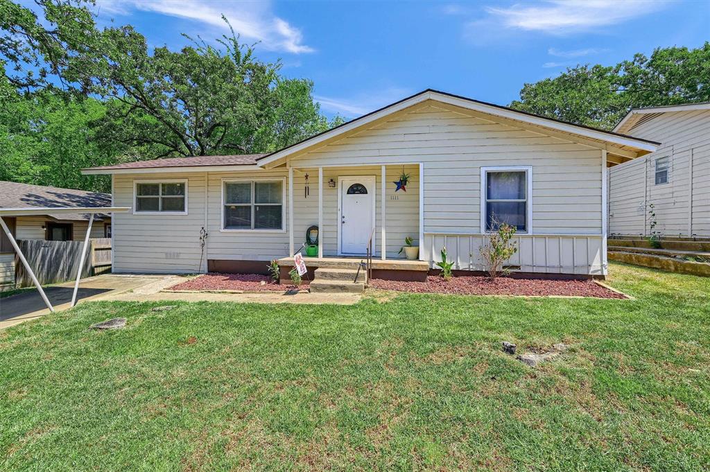 a view of a house with a yard and chairs