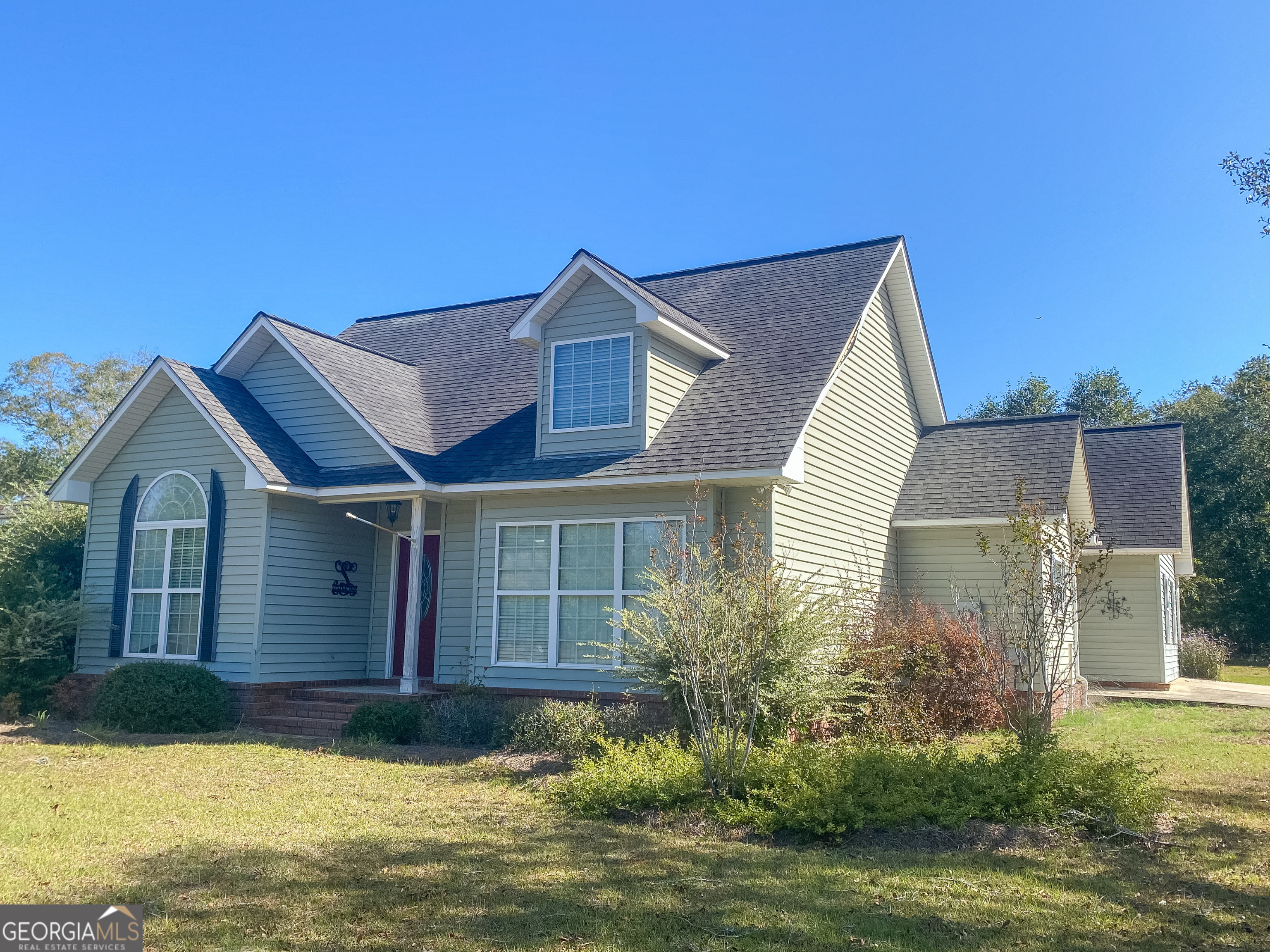 a front view of a house with a garden