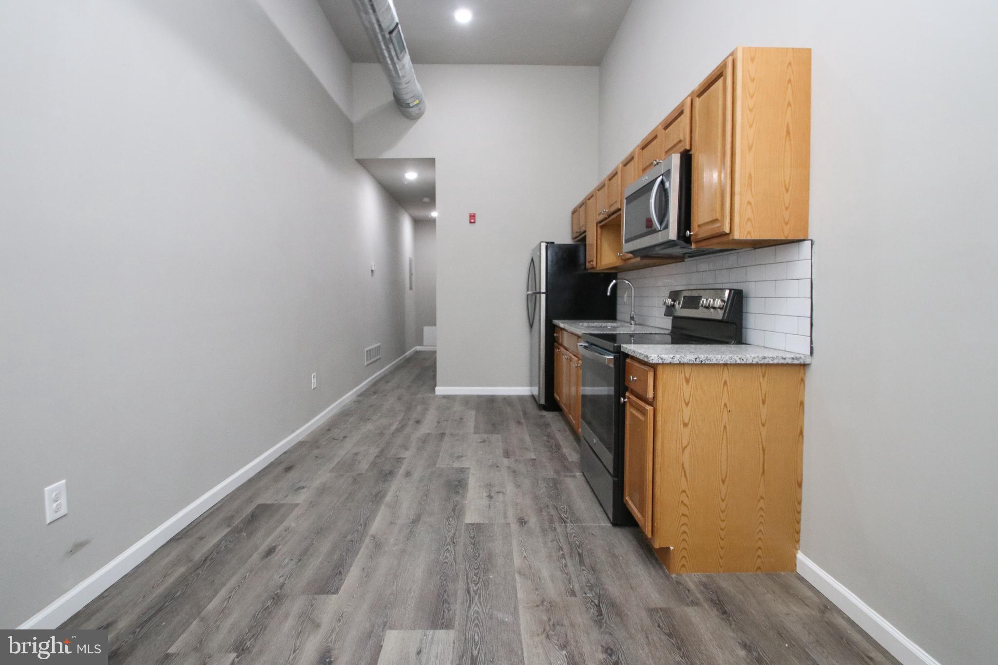 a view of a kitchen with wooden floor and a sink