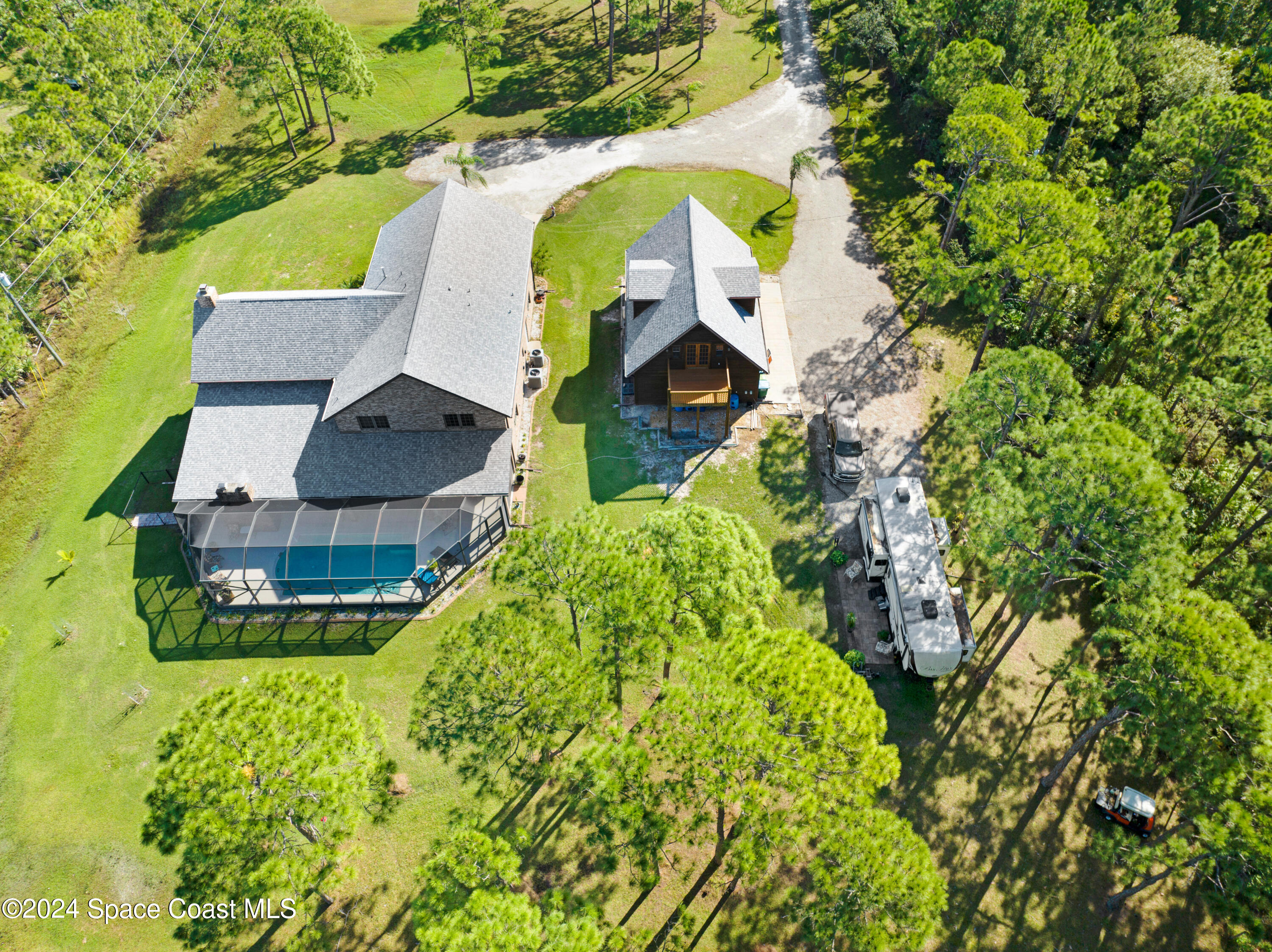 an aerial view of a house with a yard and swimming pool