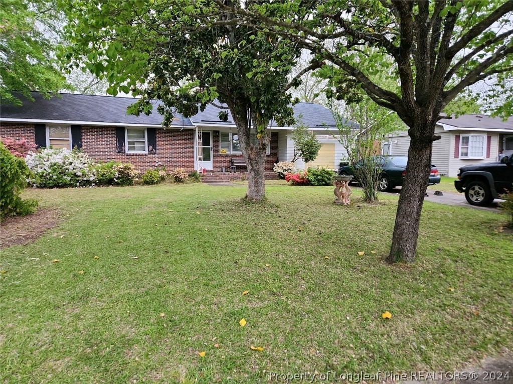 a view of a house with a yard and tree